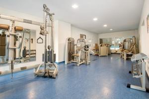 un gimnasio con cintas de correr y máquinas en una habitación en Ferienappartement Schmetterling, en Sankt Englmar
