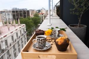 a tray of muffins and coffee cups on a balcony at Luxury suites with JACUZZI by Sea&theCity in Thessaloniki