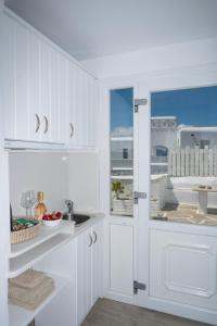 eine weiße Küche mit einem Waschbecken und einem Fenster in der Unterkunft Boutique di Vito in Mykonos Stadt