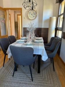 mesa de comedor con sillas azules y lámpara de araña en Apartamento Mirador del Pantano2, en Vinuesa