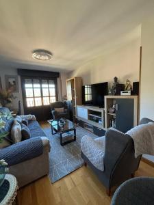 ein Wohnzimmer mit einem Sofa und einem TV in der Unterkunft Apartamento Mirador del Pantano2 in Vinuesa