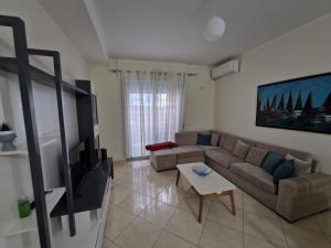 a living room with a couch and a tv at Appartamento Perla in Vlorë