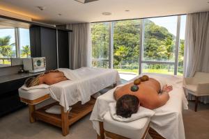 two people laying in beds in a hospital room at Hotel Nacional in Rio de Janeiro