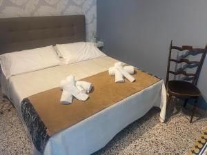 two towels on a bed with a chair at La locanda di Alice in Altamura