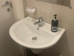 a white bathroom sink with a soap dispenser on it at La locanda di Alice in Altamura