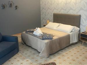 a bedroom with a bed and a blue chair at La locanda di Alice in Altamura +27 photos