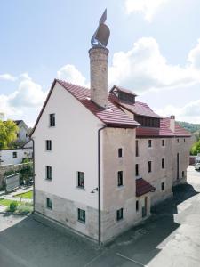 ein altes Gebäude mit einem Turm darüber in der Unterkunft Ferienwohnungen - Alte Brauerei in Rauhenebrach