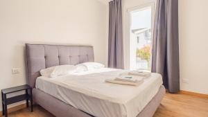 ein Schlafzimmer mit einem Bett mit zwei Handtüchern darauf in der Unterkunft Rosa Dei Venti - Italian Homing in Padenghe sul Garda + 11 Fotos