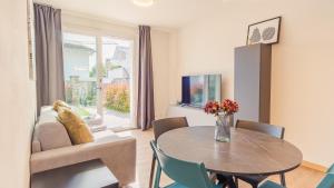 ein Wohnzimmer mit Tisch und Couch in der Unterkunft Rosa Dei Venti - Italian Homing in Padenghe sul Garda