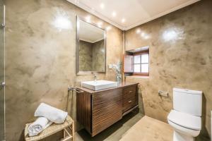 a bathroom with a sink and a toilet and a mirror at Stunning 13th Century Luxury Villa* Garden & Pool in Avila