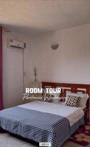 a bedroom with a bed with a room tour sign on the wall at Appartement 1 chambre, 1 salon, 1 balcon, Immeuble T Bella, Calafatas, Yaoundé in Yaoundé