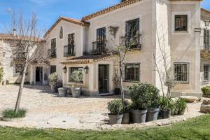 ein großes weißes Haus mit Pflanzen davor in der Unterkunft Stunning 13th Century Luxury Villa* Garden & Pool in Avila