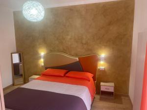 Azzano San PaoloにあるB&B Aeroportoのベッドルーム1室(オレンジ色の枕が付いたベッド1台付)