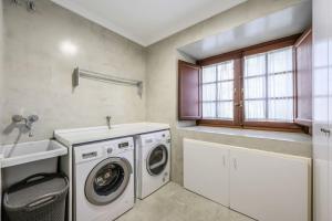 eine Waschküche mit Waschmaschine und Waschbecken in der Unterkunft Stunning 13th Century Luxury Villa* Garden & Pool in Avila