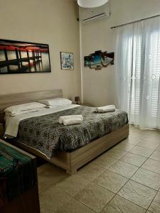 1 dormitorio con 1 cama con 2 toallas en Villa GLORIA intero alloggio sulla spiaggia 8 posti letto 15 minuti da Palermo e 35 da Cefalu, en Casteldaccia