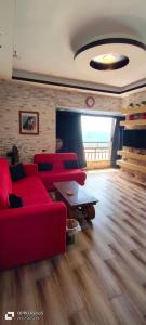 ein Wohnzimmer mit einem roten Sofa und einem Tisch in der Unterkunft شقه فندقيه الايجار بالإسكندرية in Alexandria