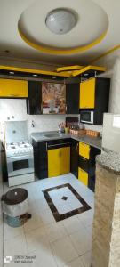 eine Küche mit gelben und schwarzen Schränken und einer Decke in der Unterkunft شقه فندقيه الايجار بالإسكندرية in Alexandria
