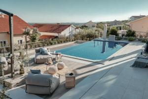a large swimming pool with two couches and a table next to at Luxury Villa Mikolina in Kornić
