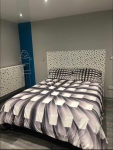 a bedroom with a bed with a black and white comforter at Chez Amandine in Osne-le-Val