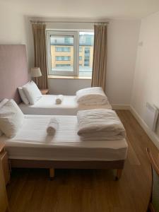 two beds in a small room with a window at City Centre Apartment in Galway - 2 Bedrooms in Galway