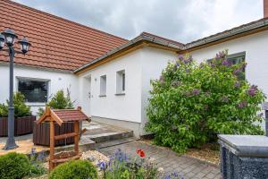 a white house with a garden and flowers at Ferienwohnung zum Specht in Spechtritz