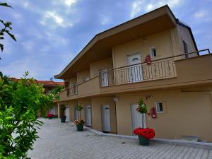 a building with two balconies and potted plants on it at Mente Libre Villas in Nea Plagia