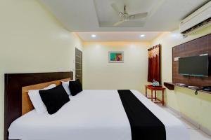 a bedroom with a bed and a flat screen tv at Collection O ANNA INN in Chennai
