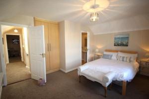 a bedroom with a large white bed and a chandelier at 2 Clifden Court in Clifden