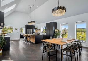 a kitchen and dining room with a wooden table and chairs at Sweet Garden, Mannin - Ballyconneely in Ballyconneely