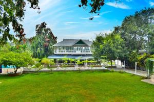 a large building in a park with a green lawn at MGM Whispering Wind's Yelagiri in Yelagiri