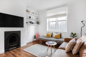uma sala de estar com um sofá e uma lareira em Central London Beautiful 2bed em Londres
