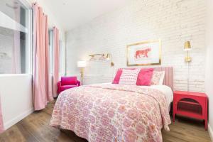 a bedroom with a pink bed and a pink chair at Kentucky Princess Pretty in Pink in Louisville