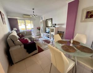 een woonkamer met een tafel en een bank bij Strandnära boende i Torrox Costa in Torrox Costa