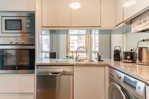 una cocina con fregadero y lavavajillas en Breeze Apartment - Matosinhos, en Matosinhos