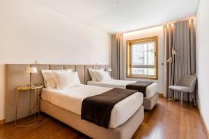 Habitación de hotel con 2 camas y ventana en Breeze Apartment - Matosinhos en Matosinhos