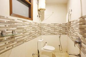 un piccolo bagno con servizi igienici e specchio di Hotel Red Stone Mahipalpur a Nuova Delhi