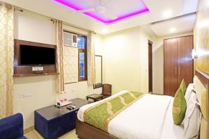 een hotelkamer met een bed en een televisie bij Hotel Red Stone Mahipalpur in New Delhi