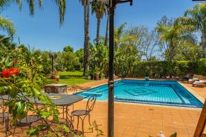 a swimming pool with a table and chairs next to it at Villa Gialla in Aci Catena