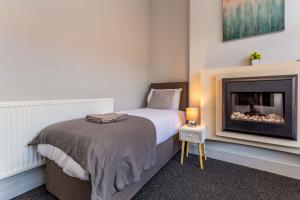 1 dormitorio con 1 cama y chimenea en Spectacular House with Patio in Carlisle, en Carlisle