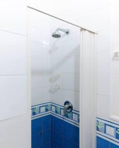 a bathroom with a shower with blue and white tiles at Davids Room Palazzo Tamborino in Lecce