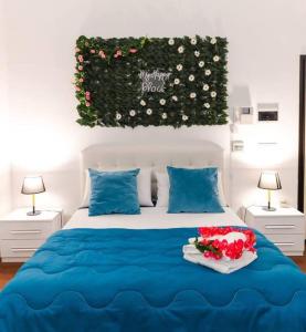 a bedroom with a blue bed with flowers on it at Davids Room Palazzo Tamborino in Lecce