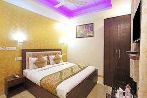 een slaapkamer met een bed en een tv in een kamer bij Hotel Red Stone Mahipalpur in New Delhi