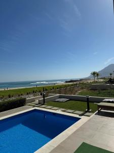a swimming pool with a view of the beach at Water Front Villa BF108 in Muscat