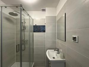 a bathroom with a glass shower and a sink at Apartamenty Sunny Stay Jastarnia in Jastarnia