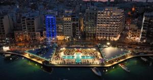 una gran piscina en medio de una ciudad por la noche en Gzira Centre Apartment - Close to the Sea, en Il-Gżira