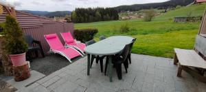 einen Tisch und Stühle auf einer Terrasse in der Unterkunft Mon cocon in Xonrupt-Longemer