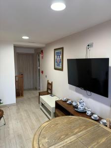 a living room with a flat screen tv on the wall at HOTEL RURAL LOS FAROLES in Huérmeces
