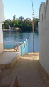 uma vista para um rio com um banco ao fundo em charming nubian guest house em Aswan