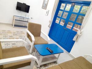 a living room with a blue door and two chairs at Olive Garden Apartment in Candolim