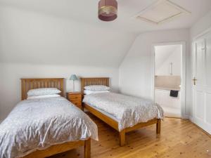 1 dormitorio con 2 camas y espejo en Lake House Mannin, Ballyconneely, en Ballyconneely